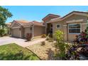 Attractive home featuring a tile roof, three-car garage and landscaped front yard at 11982 Granite Woods Loop, Venice, FL 34292