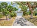 Detached one-car garage with a concrete driveway and mature shade trees at 12018 Saragossa Ln, North Port, FL 34287