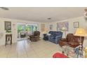 Bright living room featuring neutral tile flooring and a sunroom at 12018 Saragossa Ln, North Port, FL 34287