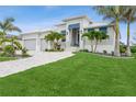 Stunning home featuring lush landscaping, a paved driveway, and a modern architectural design at 1306 Osprey Dr, Punta Gorda, FL 33950