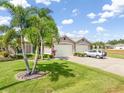 Spacious property features lush lawn, mature trees, and a two-car garage with ample parking at 1327 Hedgewood Cir, North Port, FL 34288