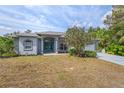 Inviting single-story home featuring manicured landscaping, a gray exterior, and a spacious driveway at 1513 Urmey Ln, North Port, FL 34286