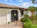 Charming front entrance with decorative door, stone accents, and lush landscaping providing great curb appeal at 158 Norman St, Port Charlotte, FL 33954
