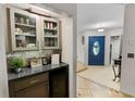 Inviting hallway features a built-in bar area, a striking blue front door, and decorative tile flooring at 22498 Westchester Blvd, Punta Gorda, FL 33980