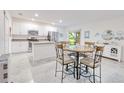 Bright open kitchen with stainless appliances, an island, and an adjacent dining area with a table at 25324 Aysen Dr, Punta Gorda, FL 33983