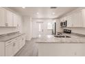 Well-lit kitchen with white cabinets, granite countertops, and stainless steel appliances at 28218 N Twin Lakes Dr, Punta Gorda, FL 33955