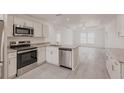 Modern kitchen with stainless steel appliances, granite countertops, and adjacent living room at 28218 N Twin Lakes Dr, Punta Gorda, FL 33955