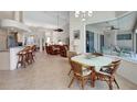 Open-concept dining area with tile floors, a ceiling fan, chandelier, and view of the pool area at 2833 La Mancha Ct, Punta Gorda, FL 33950