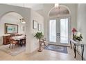 Bright foyer with tile flooring, white double doors, and arched window above, opening to the dining room at 2833 La Mancha Ct, Punta Gorda, FL 33950