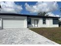Charming single-story home boasting a two-car garage and a patterned brick driveway at 3045 Montgomery Dr, Port Charlotte, FL 33981
