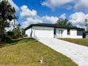 Well-maintained single-story home features a two-car garage and a lovely patterned brick driveway at 3045 Montgomery Dr, Port Charlotte, FL 33981