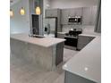 Bright kitchen features gray cabinets, quartz countertops, stainless appliances, and center island at 3560 Elias Cir, North Port, FL 34288