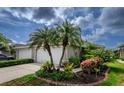 Charming home exterior featuring lush landscaping and a well-manicured lawn at 3702 Lakewood Blvd, North Port, FL 34287