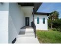 Stylish home entrance with modern door, stucco siding, and neat landscaping at 3920 Wisteria Pl, Punta Gorda, FL 33950