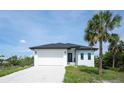 Charming single-story home boasting a white exterior, dark trim, and well-maintained landscaping at 3920 Wisteria Pl, Punta Gorda, FL 33950