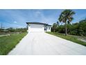 Well-maintained home featuring a long driveway and a clean white exterior with dark window trim at 3920 Wisteria Pl, Punta Gorda, FL 33950
