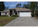 Charming one-story home featuring an attached two car garage and well-manicured lawn at 4027 Quaker Ln, North Port, FL 34288