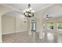 Open-concept foyer with arched details, stylish chandeliers and tile flooring, offering a sophisticated ambiance at 8183 Deland St, Port Charlotte, FL 33981