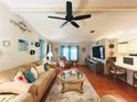 Cozy living room featuring a ceiling fan, comfortable seating, and a seamless flow to the adjacent kitchen at 857 Seabrooke Dr, Englewood, FL 34223