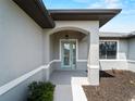Inviting front entryway with arched porch, stylish door, and landscaped garden at 97 Pine Valley Ln, Rotonda West, FL 33947