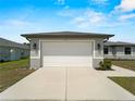 Spacious two-car garage with white door and concrete driveway of a well-maintained home at 97 Pine Valley Ln, Rotonda West, FL 33947
