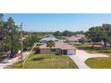 Well-maintained home features a spacious front yard, mature landscaping, and a convenient driveway leading to an attached garage at 10112 Willmington Blvd, Englewood, FL 34224