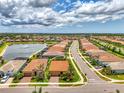Aerial view of a home on a street in a residential community with a lake at 11819 Sistine Ln, Venice, FL 34293
