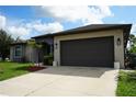 Beautiful one-story house featuring a gray stucco exterior, a driveway, and an attached garage at 1480 Wise Dr, North Port, FL 34286