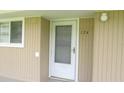 Exterior entrance showing the unit number and beige siding, adjacent to window at 150 Harborside Ave # 124, Punta Gorda, FL 33950