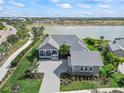 Beautiful home situated by a lake, showcasing well-manicured lawns and a paved driveway at 17213 Bullhorn Cir, Punta Gorda, FL 33982