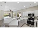Bright kitchen featuring white cabinetry, stainless steel appliances, and a breakfast bar at 181 Padova Way, Nokomis, FL 34275