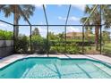 Sparkling pool featuring a screened enclosure and lush tropical landscaping at 181 Padova Way # 19, Nokomis, FL 34275