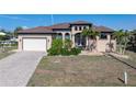 Attractive single-Gathering home with a well-manicured lawn and a brick paved driveway with a two-car garage at 18602 Ashcroft Cir, Port Charlotte, FL 33948
