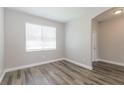 This bright bedroom offers plenty of natural light with a large window and beautiful wood-style flooring at 20067 Oakflower Ave, Tampa, FL 33647