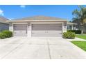 A spacious three car garage offers ample parking and storage with a large driveway in front of the home at 20067 Oakflower Ave, Tampa, FL 33647