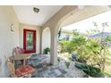 Inviting front porch featuring tiled flooring, seating, and vibrant plants at 2008 Pellam Blvd, Port Charlotte, FL 33948