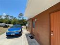 A blue Ford Focus is parked alongside the home's exterior with a hello doormat at 2328 Picnic St, Port Charlotte, FL 33952