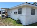 Back exterior of home with white vinyl siding and a small tomato garden at 2328 Picnic St, Port Charlotte, FL 33952