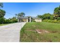 Attractive single-story home with a large driveway, attached garage, and a well-kept front yard at 2381 Sheila Ln, North Port, FL 34286