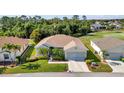 A well-maintained single-story house from above, featuring a manicured lawn, and mature landscaping at 24371 Folkstone Ave, Punta Gorda, FL 33980