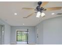 Bright living room featuring new light wood flooring, neutral paint, and a modern ceiling fan at 27050 Pelotas Dr, Punta Gorda, FL 33983