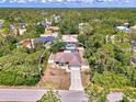 An aerial view shows a home with a screened pool area surrounded by trees in a lovely neighborhood at 3021 Toluca Ter, North Port, FL 34286