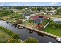 Aerial view of a home featuring a screened-in pool and waterfront access with a private dock at 3301 Santa Barbara Dr, Punta Gorda, FL 33983