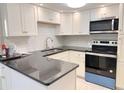 Bright kitchen features white cabinets, subway tile backsplash, and stainless steel appliances at 4158 Tamiami Trl # A5, Port Charlotte, FL 33952