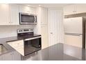 Well-equipped kitchen with stainless steel microwave, range, and refrigerator at 4158 Tamiami Trl # A5, Port Charlotte, FL 33952
