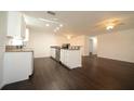 Open kitchen featuring granite countertops, sleek stainless steel appliances, and dark wood flooring at 514 Showalter Ave, Punta Gorda, FL 33950