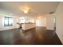 Spacious open-concept living room featuring modern dark floors, white walls, and stylish ceiling fans at 514 Showalter Ave, Punta Gorda, FL 33950