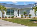 Charming single-story home boasting a landscaped front yard with meticulous shrubbery and a modern metal roof at 6286 Coniston St, Port Charlotte, FL 33981
