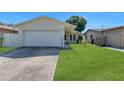 Single-story home with a well-maintained lawn and a two-car garage at 6841 46Th N St, Pinellas Park, FL 33781