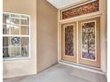 Close-up on front doors with decorative glass inserts and unique window above the door providing natural light at 78 Zenith St, Port Charlotte, FL 33954